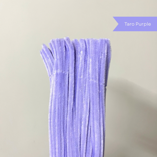 A bundle of lavender purple pipe cleaners standing upright against a plain white background, with a label in the top right corner reading 'Taro Purple'.