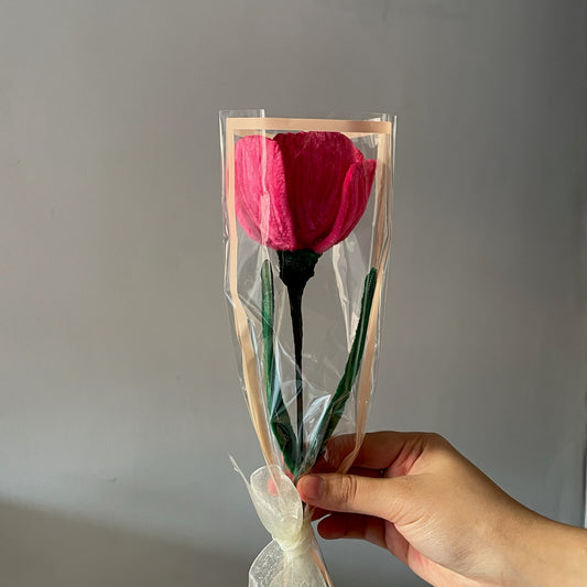a pink tulip flower made with pipe cleaners, in a cute wrapping with a ribbon